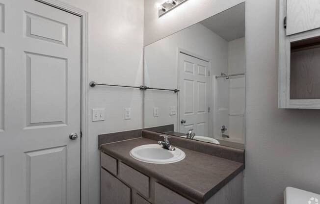 A bathroom with a sink and a mirror.