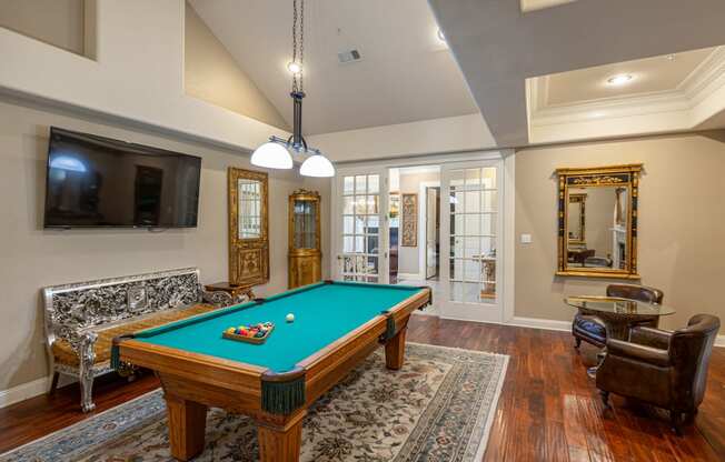 a living room with a pool table and a tv