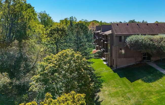 A building surrounded by trees and a green lawn.