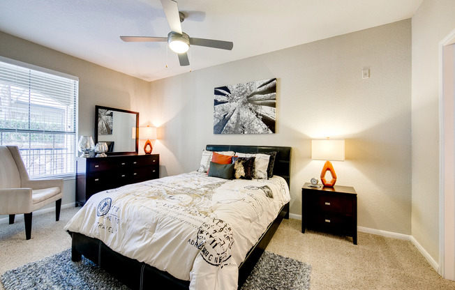 View of Upgraded Apartment Interior, Showing Bedroom with Ceiling Fan and Window View at Stonebriar of Frisco Apartments