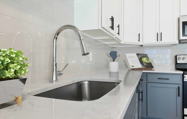 a white kitchen with a stainless steel sink and white cabinets