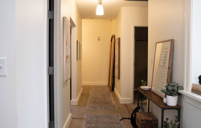 a hallway with a carpeted floor and white walls and a door