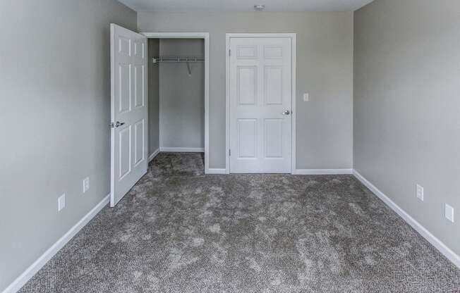 a room with a carpeted floor and a closet