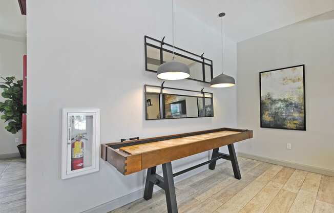 a shuffleboard table in a game room with two lights