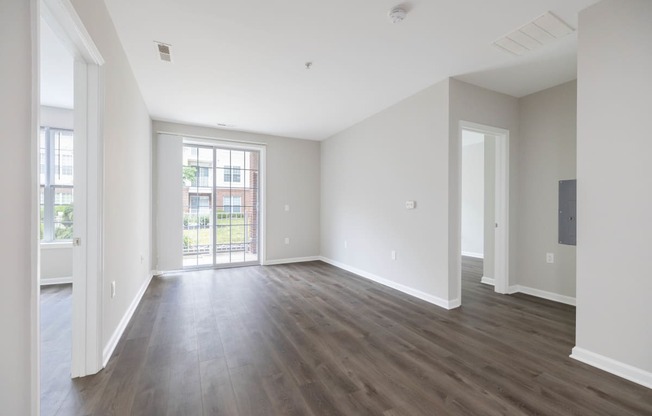 an empty living room with white walls and wood flooring