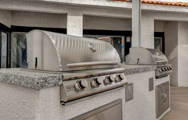 a stainless steel bbq grill is set up in the backyard of a home