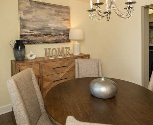 A dining room with a wooden table and chairs.