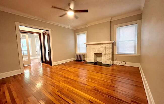 A room with a fireplace and wood flooring.
