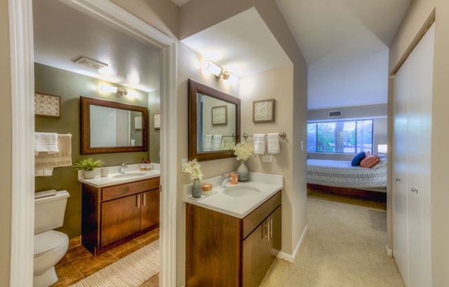a bathroom with a toilet sink and mirror at Central Park East in Arlington Heights, IL