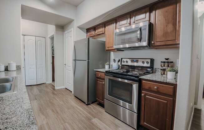 A modern kitchen with wooden cabinets and stainless steel appliances.
