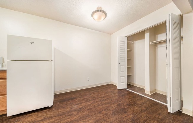a bedroom with a refrigerator and a closet