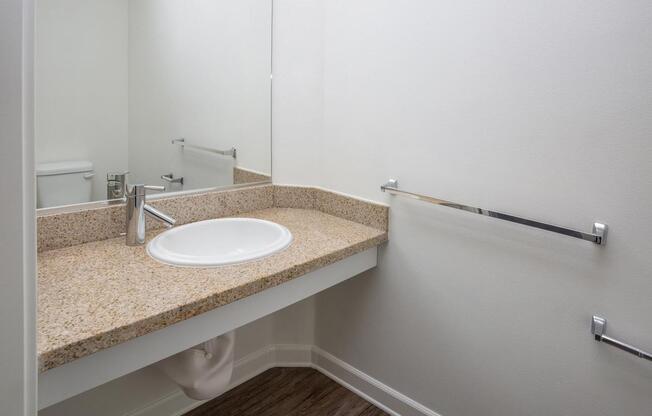 a white sink sitting under a mirror