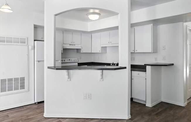 A kitchen with white cabinets and a black countertop. at Oakstone Apartments, Clearfield, UT, 84015