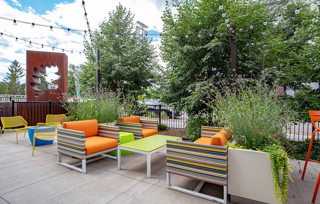 A patio with a bench and a tree.