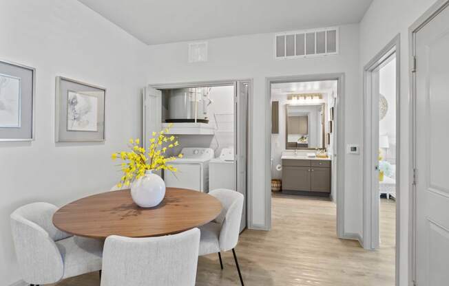 a dining room with a table and chairs      and a kitchen