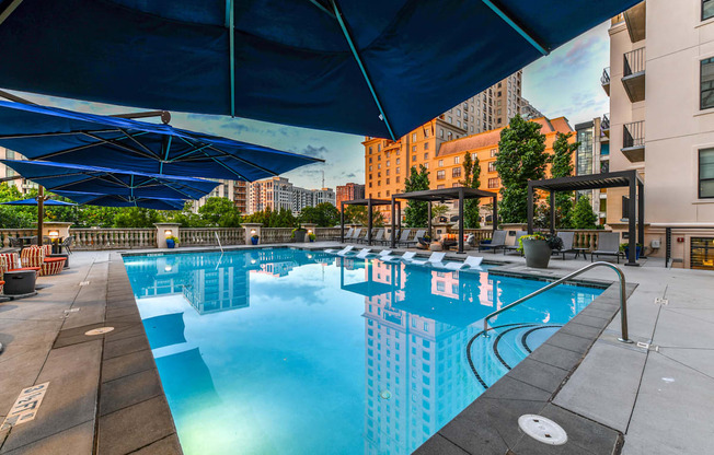 A large outdoor swimming pool with a blue canopy.