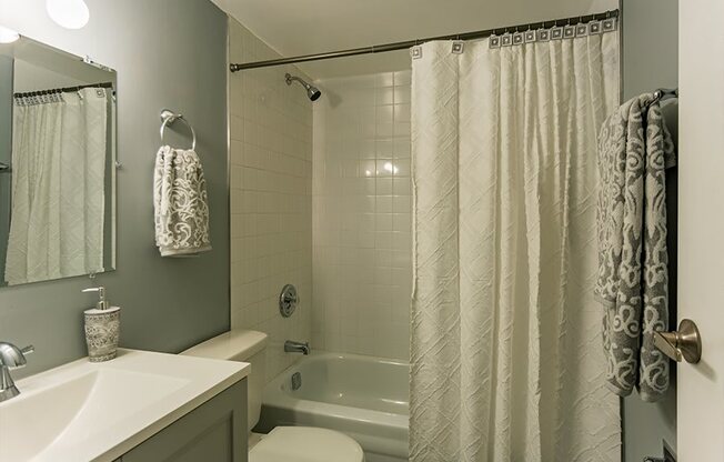 a bathroom with a shower and a sink and a toilet