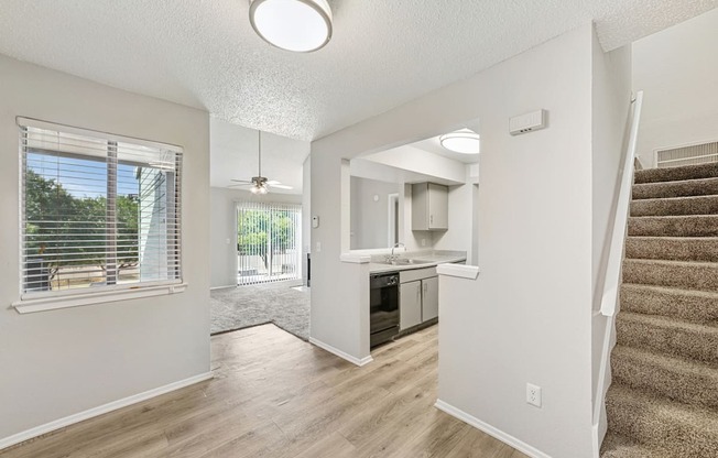 A spacious living room with a staircase leading to the upper floor.