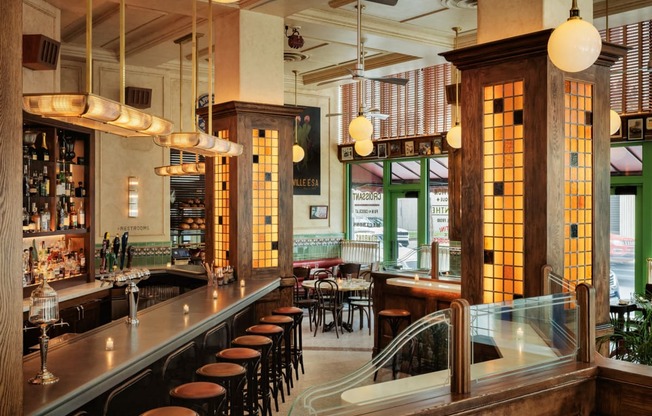 a bar in a restaurant with wooden pillars and chairsat Book Tower, Detroit, 48226