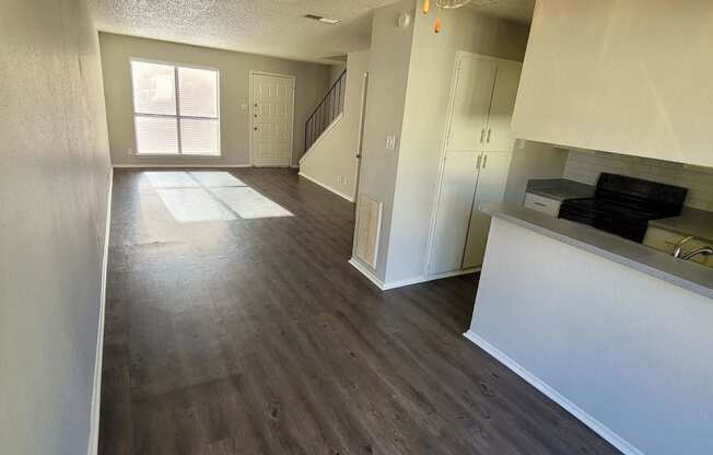 a empty living room with a ceiling fan and wood floors