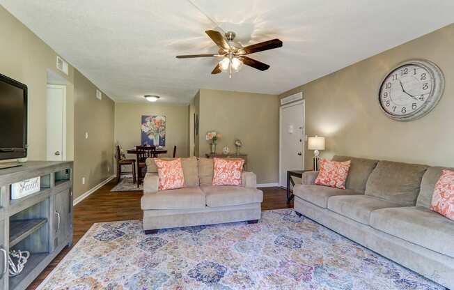 a living room with two couches and a ceiling fan