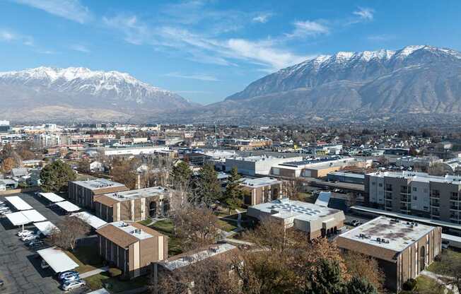 A view of a town with buildings and snow-capped mountains in the background.