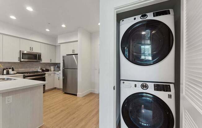 A white washing machine is in a white door.