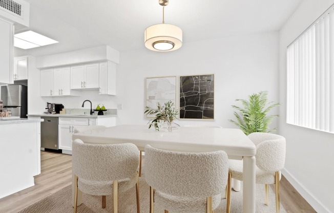 a dining room with a white table and chairs