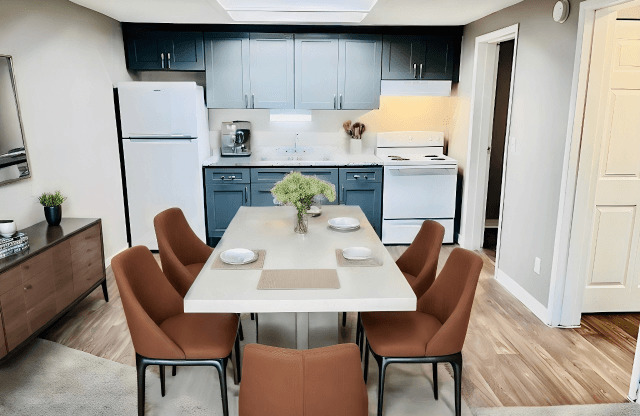 A modern kitchen with a dining table set for six.