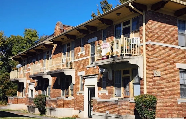A red brick building with a balcony on the second floor.