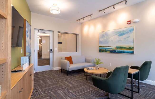 A casual lounge with a modern aesthetic, comfortable chairs, and a TV for relaxation.