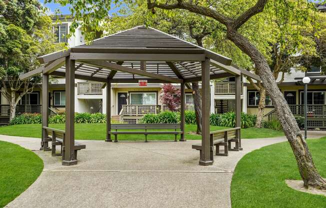 a park with a gazebo and benches in front of a building