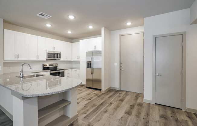 a kitchen with white cabinets and stainless steel appliances