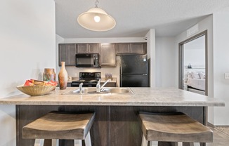 Spacious, combined kitchen and living room with breakfast bar seating.