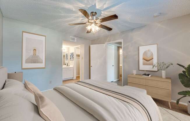 A bedroom with a large bed and a ceiling fan.