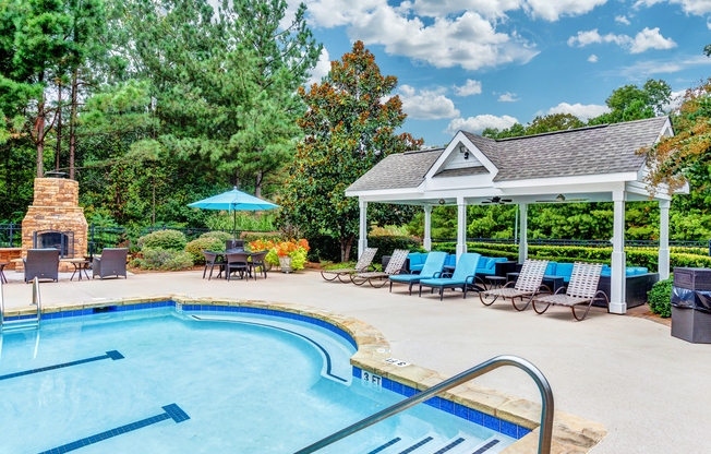 View of Pool Area, Showing Loungers, Outdoor Furniture, and Fireplace at Summer Park Apartments