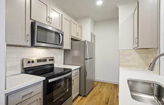 a kitchen with stainless steel appliances and white cabinets