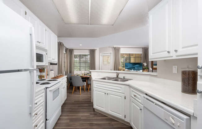 A kitchen with white cabinets and a white refrigerator.