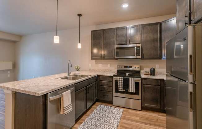 a kitchen with stainless steel appliances and a marble counter top. Fargo, ND Prairiewood Meadows | LivingFargo, ND Prairiewood Meadows