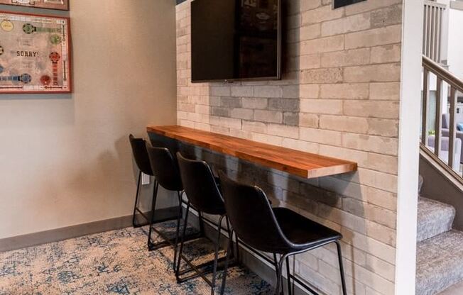 A room with a bench and chairs and a wall with a sign on it. at Vibe, Kent, Washington