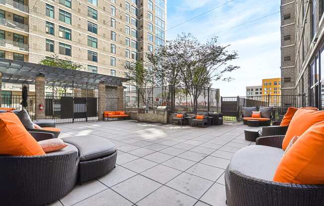 an outdoor patio with chairs and tables and a building in the background