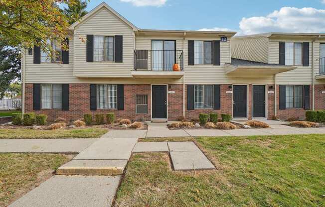 A row of townhouses with a sidewalk in front.
