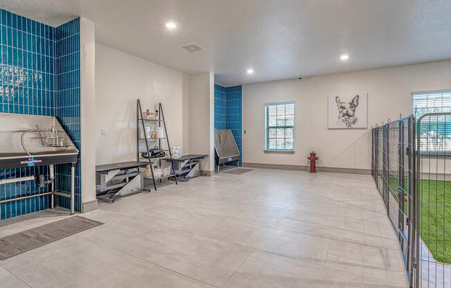 A room with a blue tiled wall and a fire hydrant.