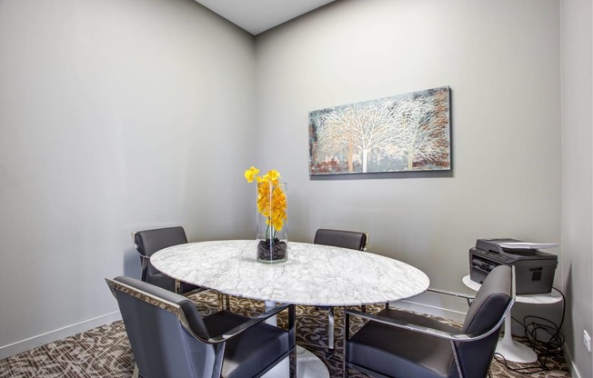 a dining room with a table and chairs and a painting on the wall