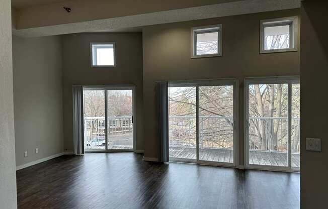 the living room of an empty house with windows and a wood floor