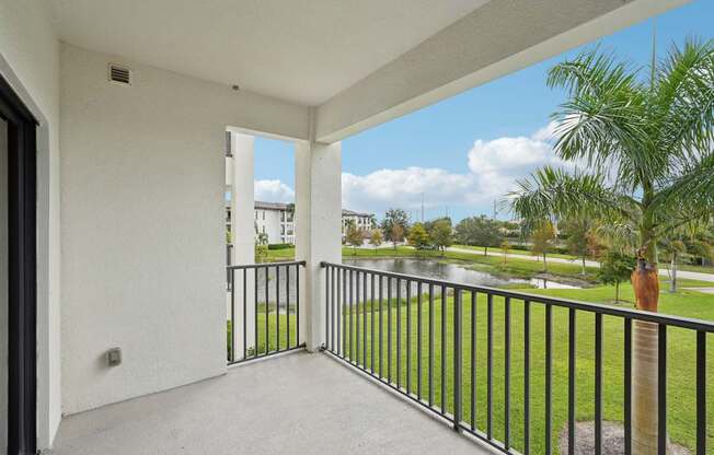 A balcony with a view of a road and trees.