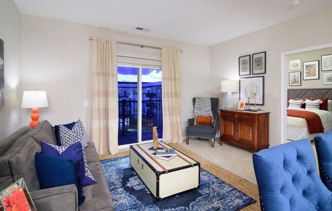 a living room with a couch and a chair and a bedroom with a bed