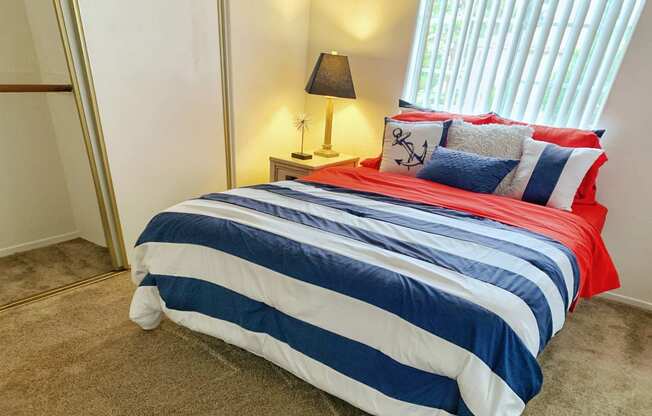 a bedroom with a bed with a striped comforter