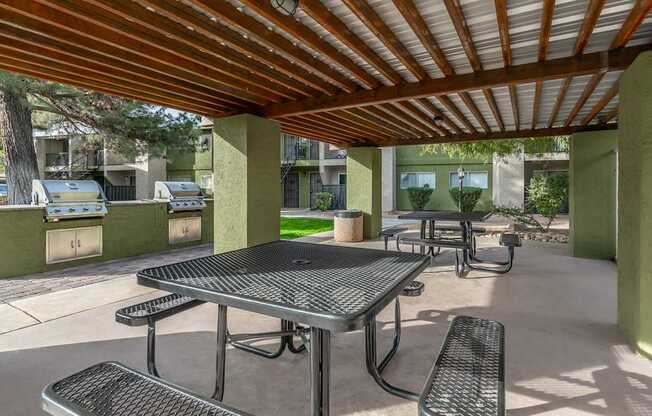 A patio with a table and chairs under a roof.