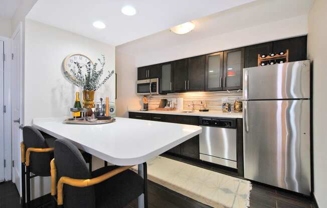 a kitchen with stainless steel appliances and a white countertop island